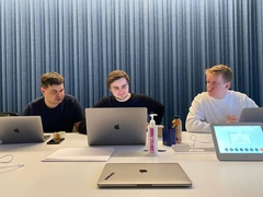 Working together around a table with laptops